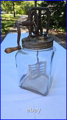 Antique 4 qt butter churn with wooden handled crank and metal paddles, glass jar
